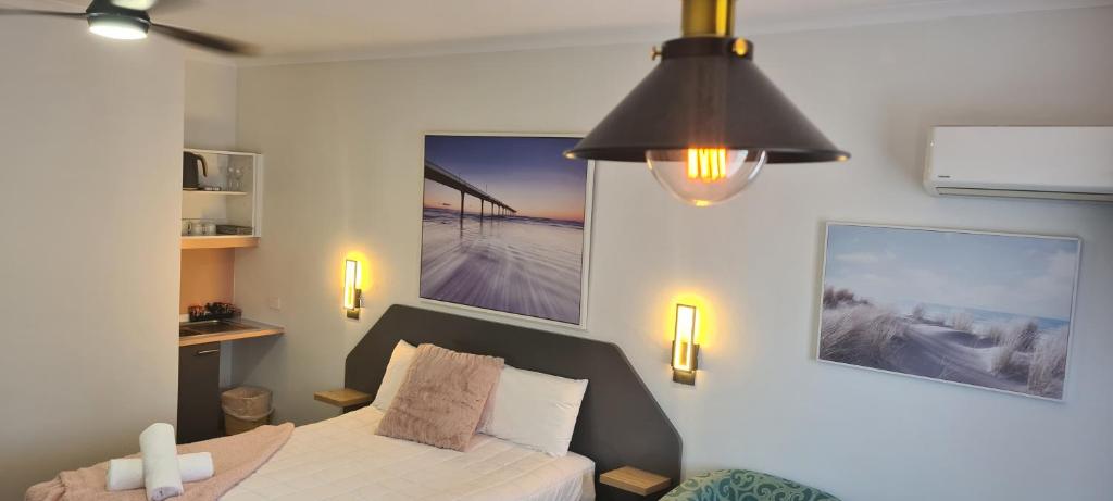 福斯特金沙汽车旅馆的一间卧室配有一张床和吊扇