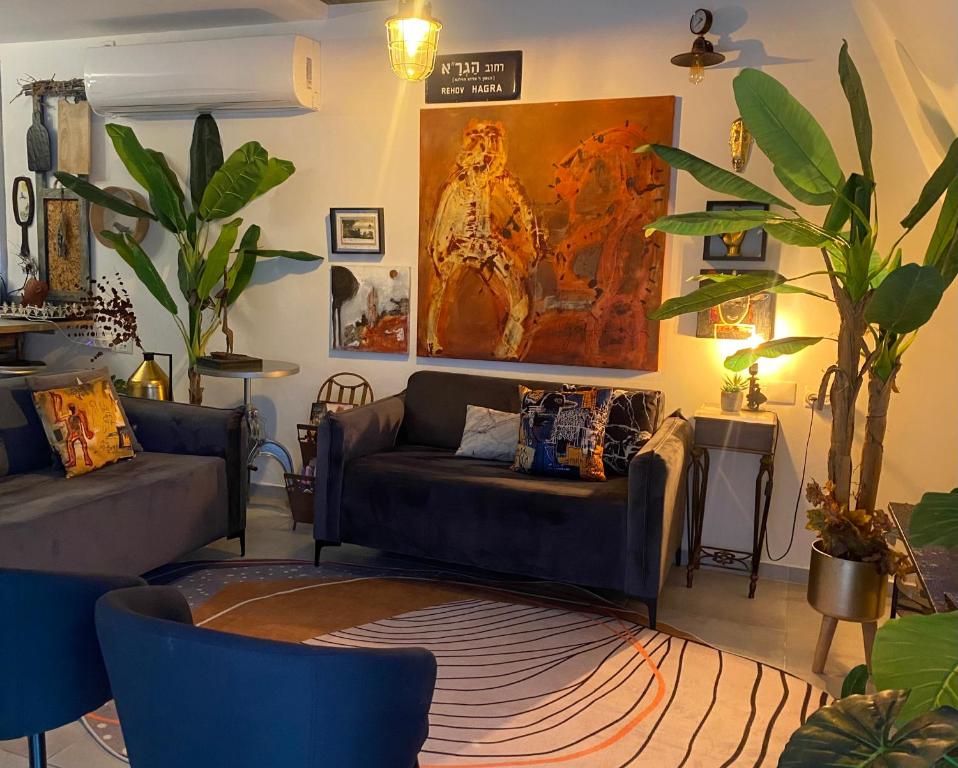特拉维夫Inspirational Apartment的客厅配有沙发和墙上的绘画