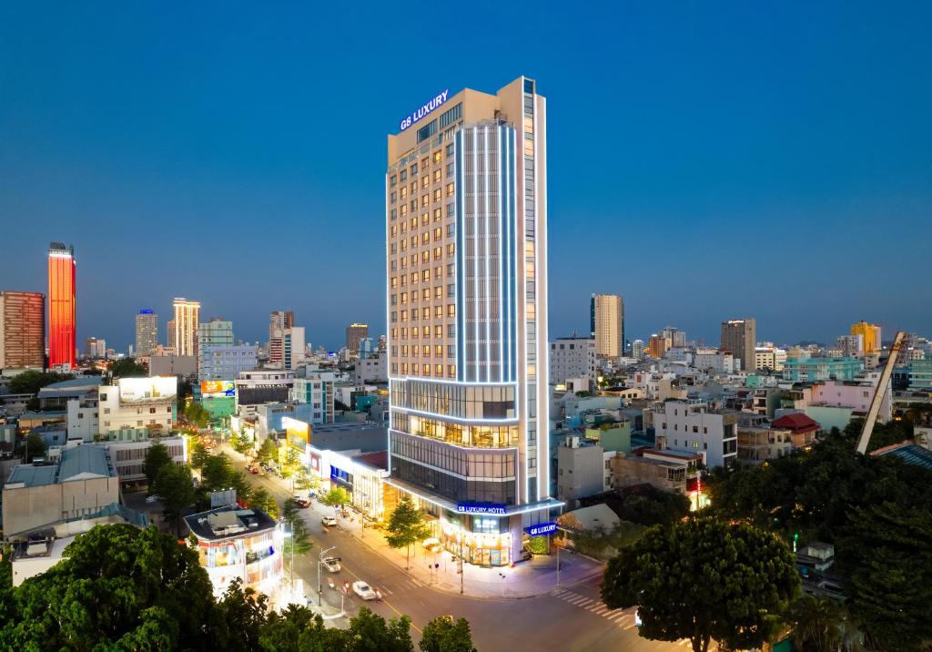岘港G8 Luxury Hotel and Spa Da Nang的城市高楼 ⁇ 染