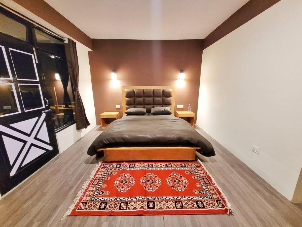 拉冲Wonder Hill Inn的卧室配有一张铺有红色地毯的床。