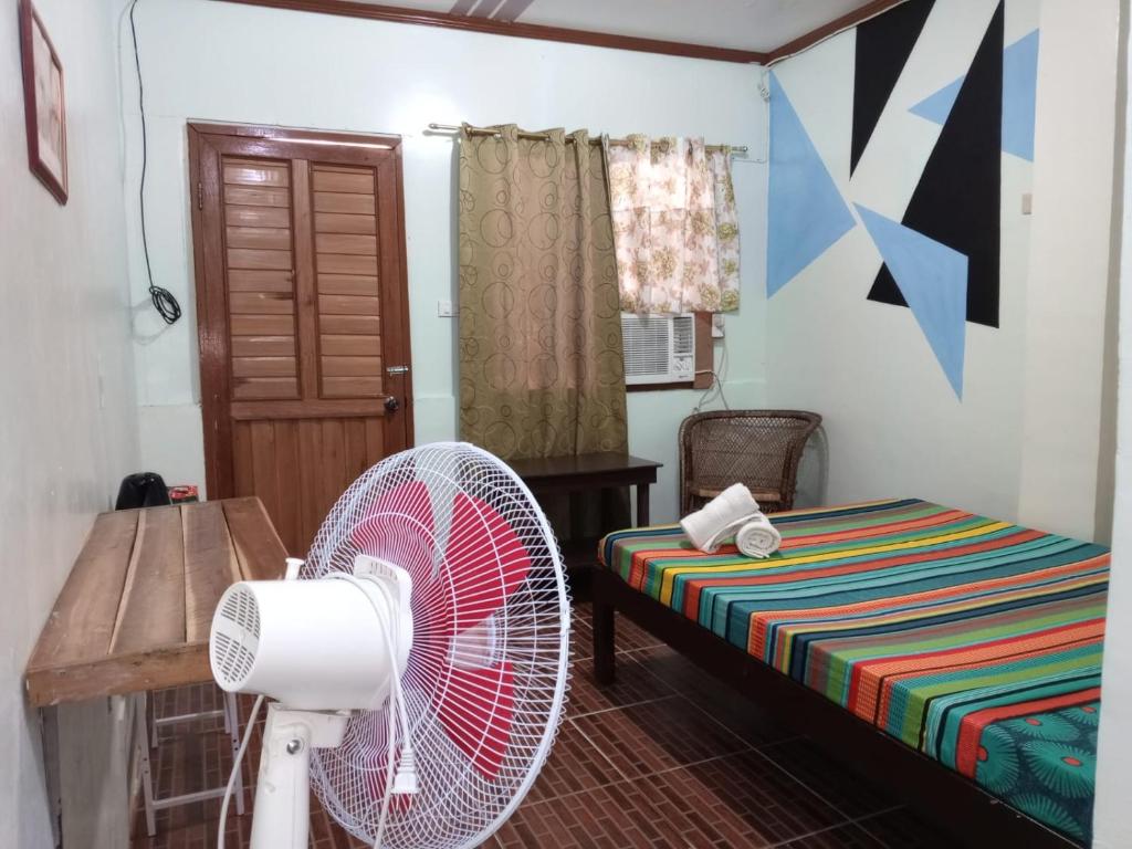 爱妮岛ALFA Garden Lodge的客房配有风扇和1张床。