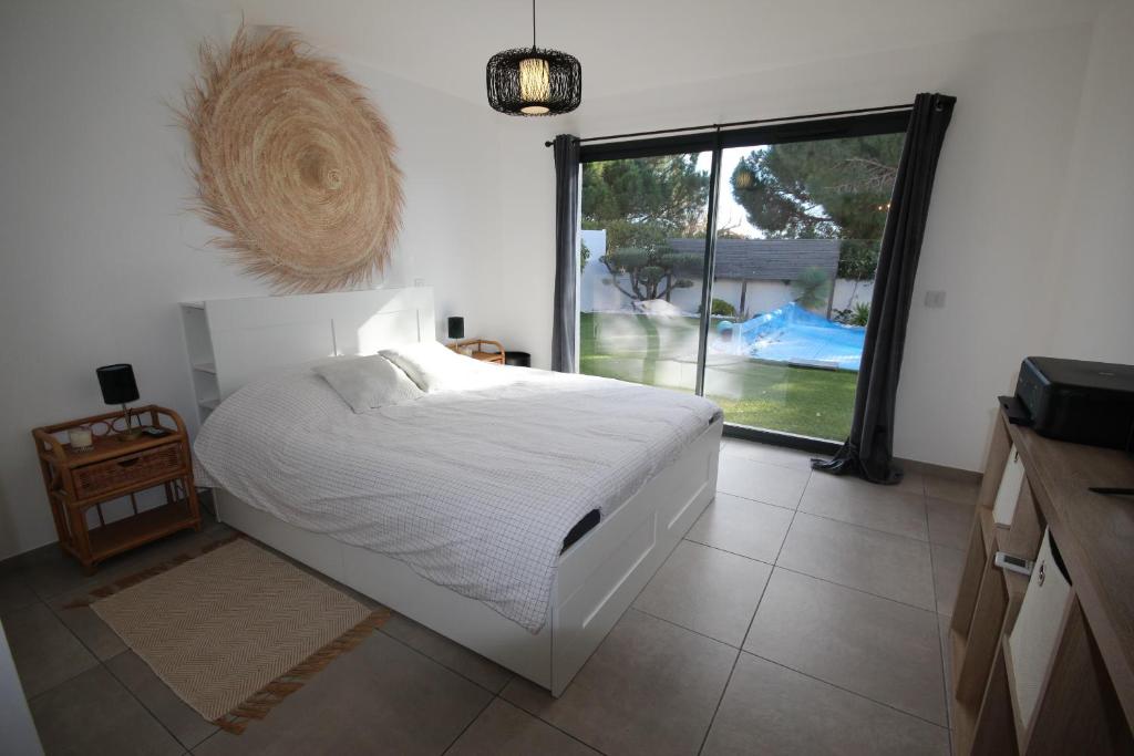 波尔蒂拉盖Belle villa contemporaine climatisee, piscine privee, 6 - 8 couchages, 3 chambres, wifi, à 3 km de la plage -LXDALI25B的卧室设有白色的床和大窗户
