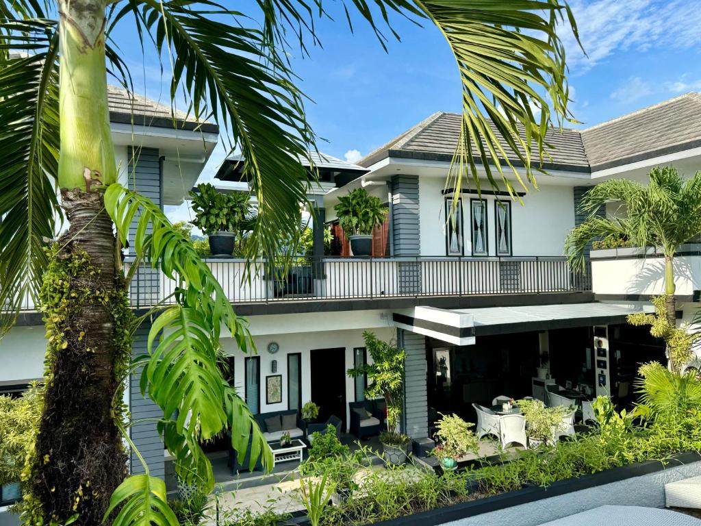 圣吉吉Villa Rumah Putih Abu Abu的享有棕榈树房屋的外部景色