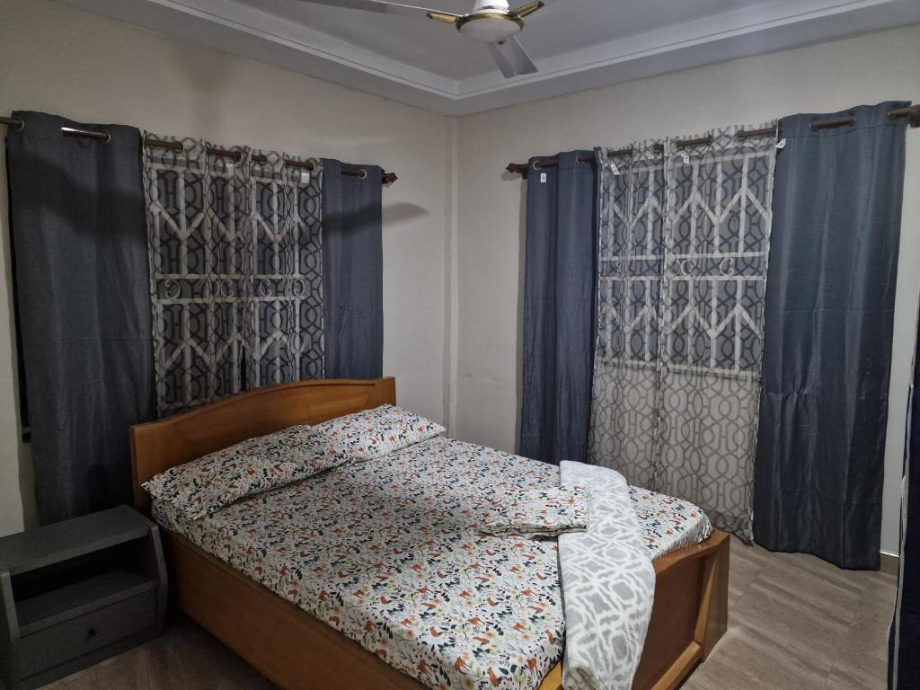 库马西Sigma Theta Homes - Kumasi Atimatim的一间卧室配有蓝色窗帘的床