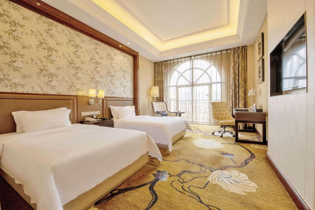 惠州惠州龙光城戴斯酒店的酒店客房配有两张床和一张书桌
