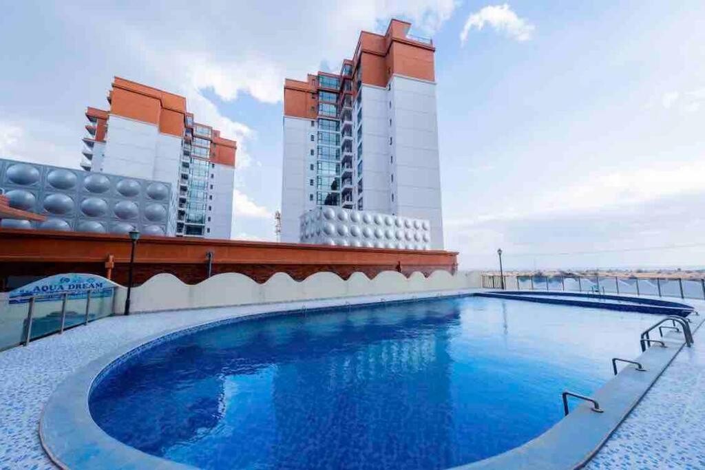 内罗毕Abantu Parkview 2BR Suite near JKIA SGR with Pool Gym Eatery的一座高楼屋顶上的游泳池
