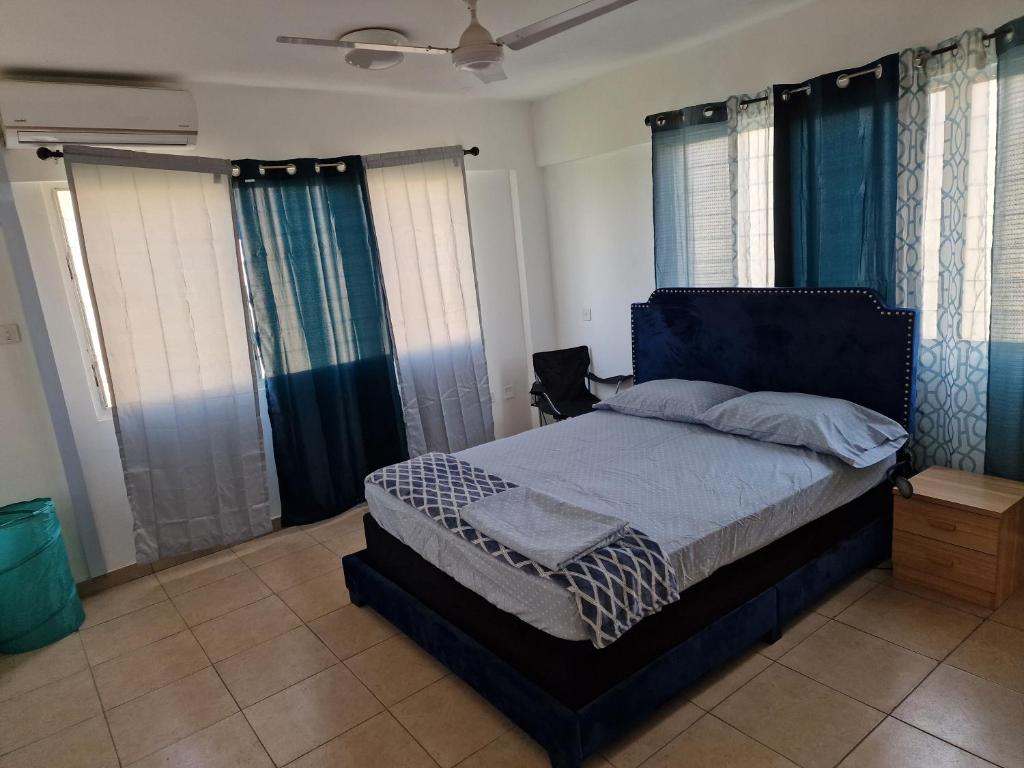 库马西Sigma Theta Homes - KNUST Area的一间卧室配有一张带蓝色窗帘的大床