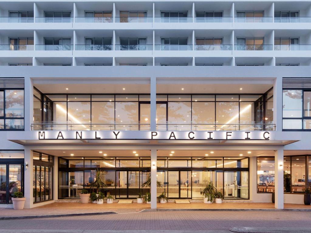 悉尼Manly Pacific Sydney MGallery Collection的一座白色的大建筑,上面有药剂师的标志