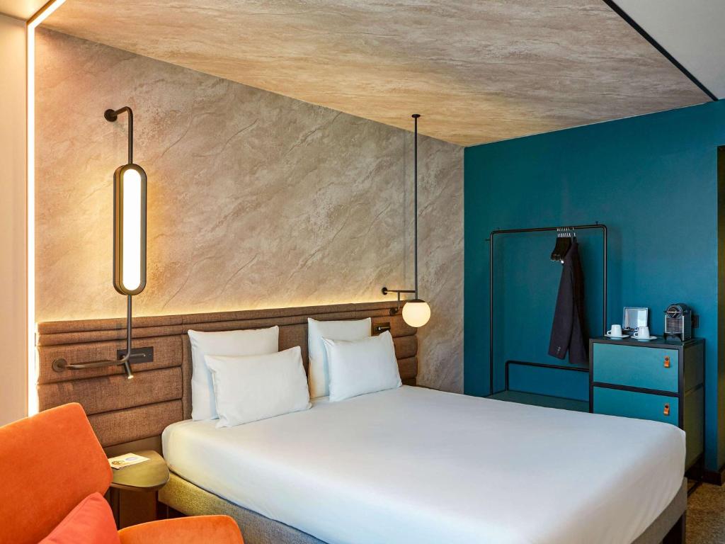 弗赖辛诺富特慕尼黑机场酒店的卧室配有白色的床和蓝色的墙壁