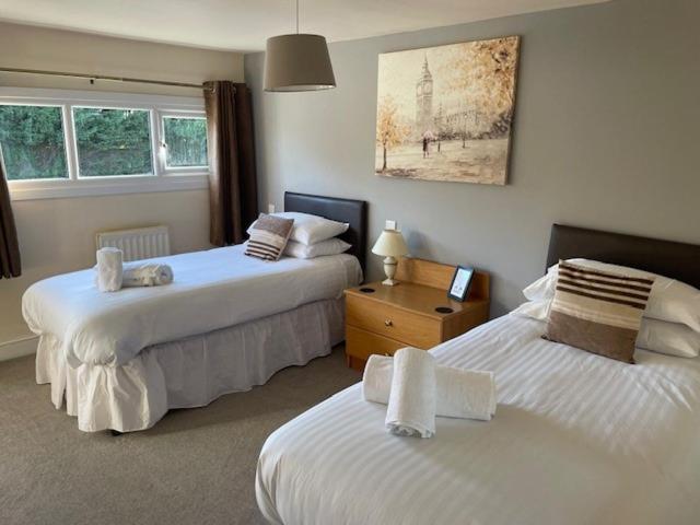 拉特沃思Chequers Country Inn的一间卧室配有两张带白色床单的床