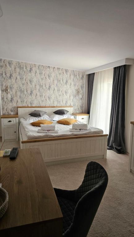 布勒伊拉天堂酒店的一间卧室配有一张大床和一张桌子