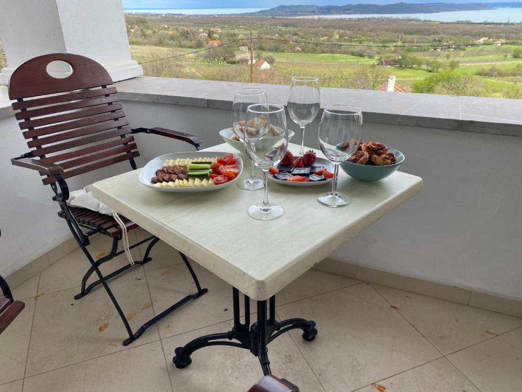 鲍洛托努德沃里Fishing & Golf Kisleshegy Balatonudvari Vendégház的酒杯桌子和一碗食物