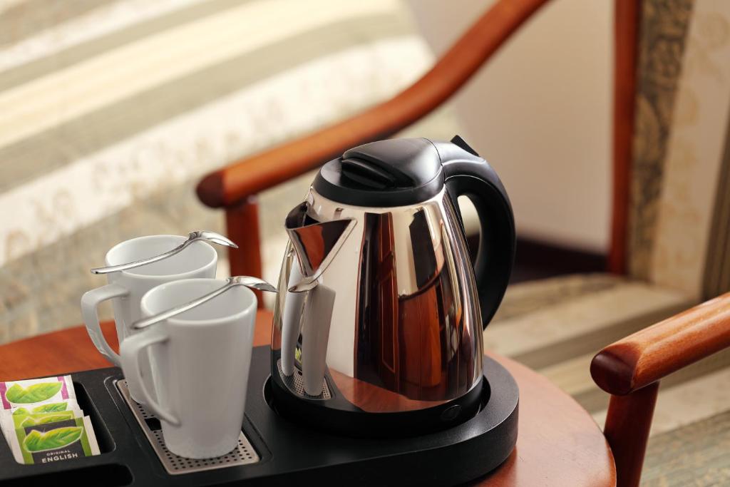 布拉格阿米戈城市中心酒店的茶壶和桌子上的两个杯子