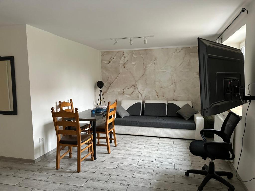 什切青Apartamenty Bezrzecze的客厅配有床和桌椅