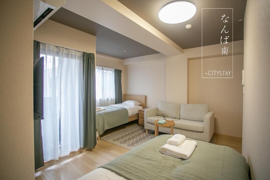大阪CityStay難波南的一间带两张床的房间和一个带沙发的客厅