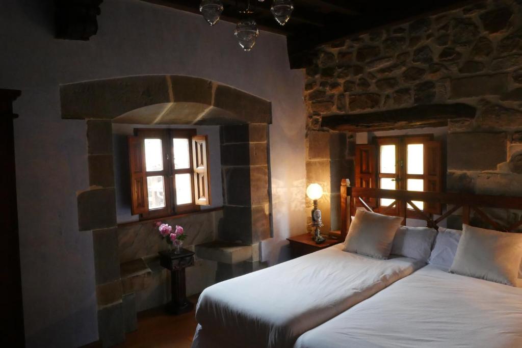 AbándamesHotel Palacio La Cajiga的一间卧室设有两张床和两个窗户。