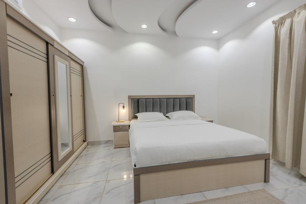 麦地那Luxurious Family 3 Bedroom Apartments 10 Mins Drive to Al-Masjid Nabawi - Qaswarah residence的白色的卧室设有床和窗户