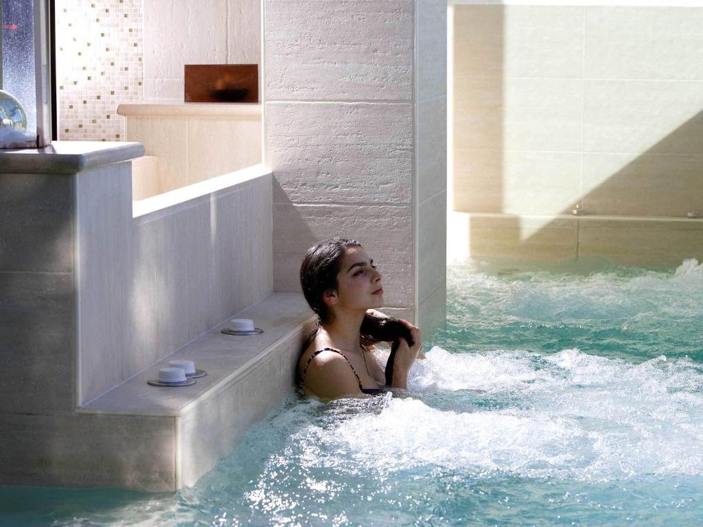 阿西西吉欧托温泉酒店的坐在热水池里的女人