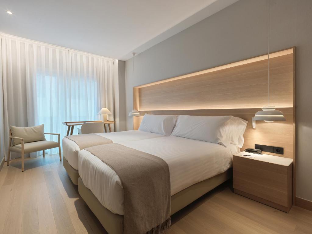 拉科鲁尼亚泽尼特拉科鲁尼亚酒店的酒店客房设有一张大床和一张桌子。