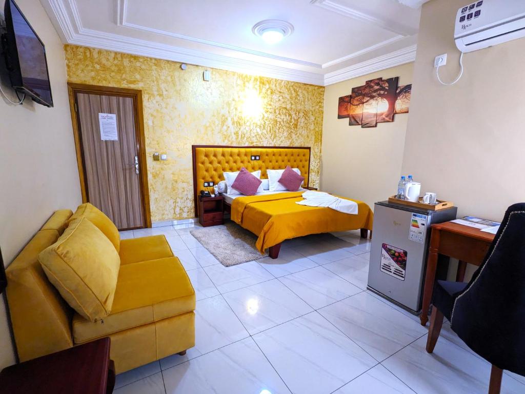 杜阿拉ALICIA HOTEL的酒店客房配有黄色的床和沙发