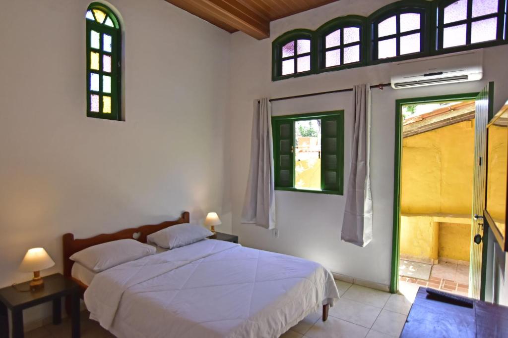 阿拉亚尔-杜卡布Villas Boas的一间卧室设有一张床和两个窗户。