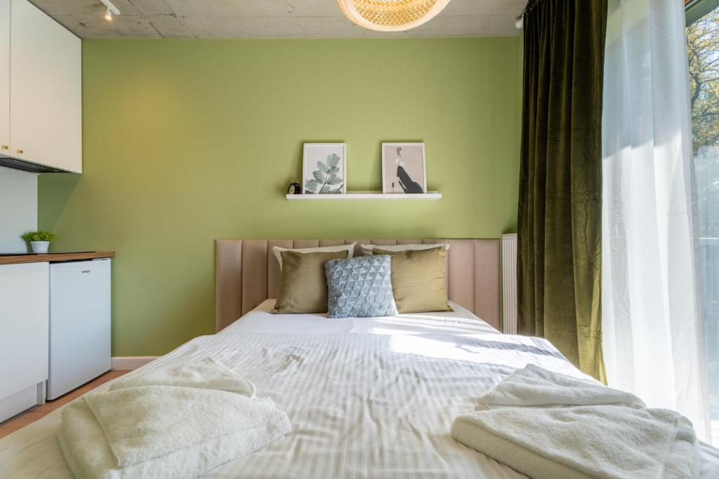 什切青Silver Forest的一间卧室设有一张带绿色墙壁的大床