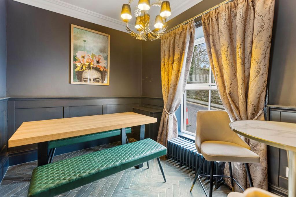 伦敦德里Hestia House的一间带桌椅和窗户的用餐室