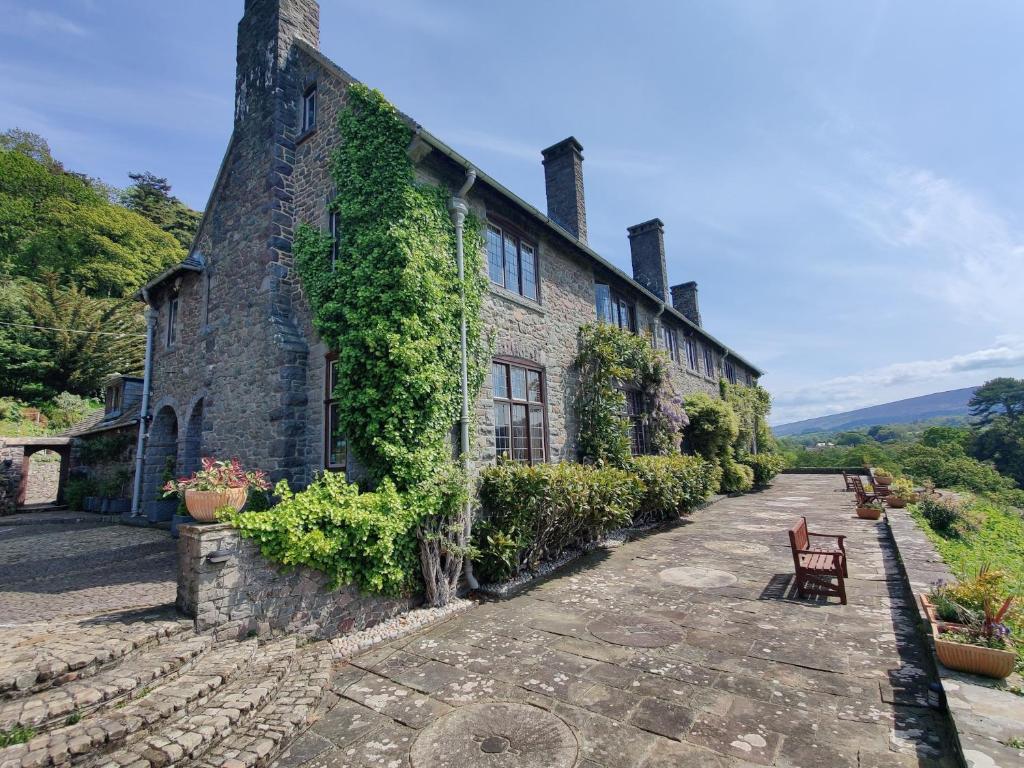 波洛克Luxury Bed And Breakfast at Bossington Hall in Exmoor, Somerset的一座石头房子,旁边是常春藤