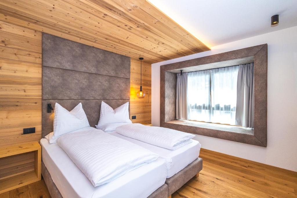 圣维吉利奥Garni Residence Alnö - Adults Only的卧室配有一张大白色床和窗户