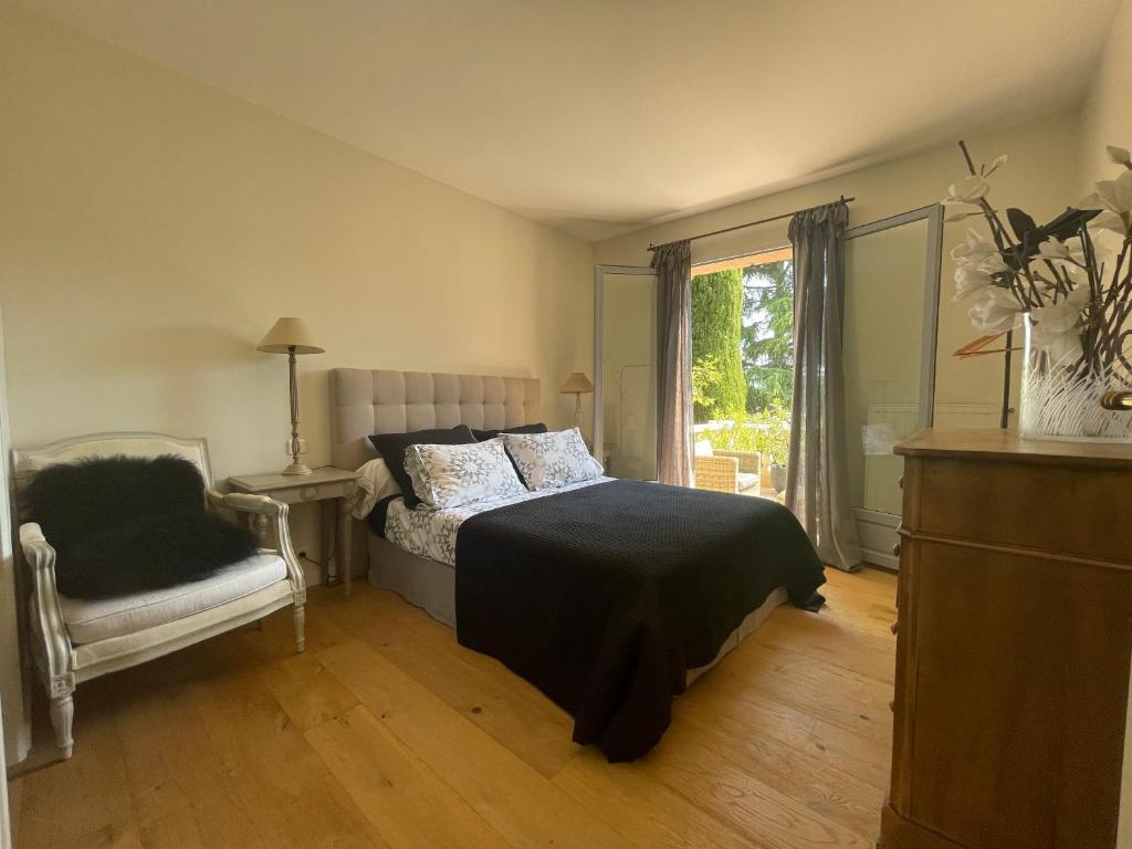 瓦洛里Carolienne的卧室配有床、椅子和窗户。