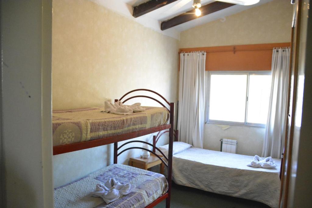 维拉卡洛斯帕兹Hotel Bellavista的一间卧室设有两张双层床和一扇窗户。