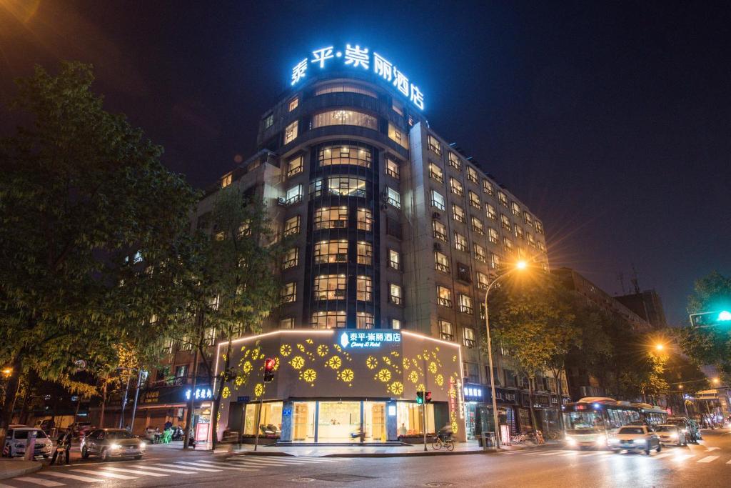 成都泰平·崇丽酒店(成都太升南路地铁站店)的一座建筑物,上面有夜间标志