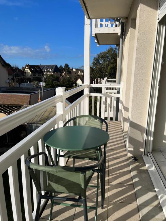 卡布尔CABOURG - 2 PIÈCES avec Balcon et parking- Hyper Centre et Plage的阳台上配有绿色的桌椅