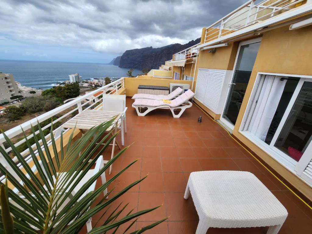 圣地亚哥港Los Gigantes,huge terrace,sea view,air conditioning的阳台配有椅子,享有海景。
