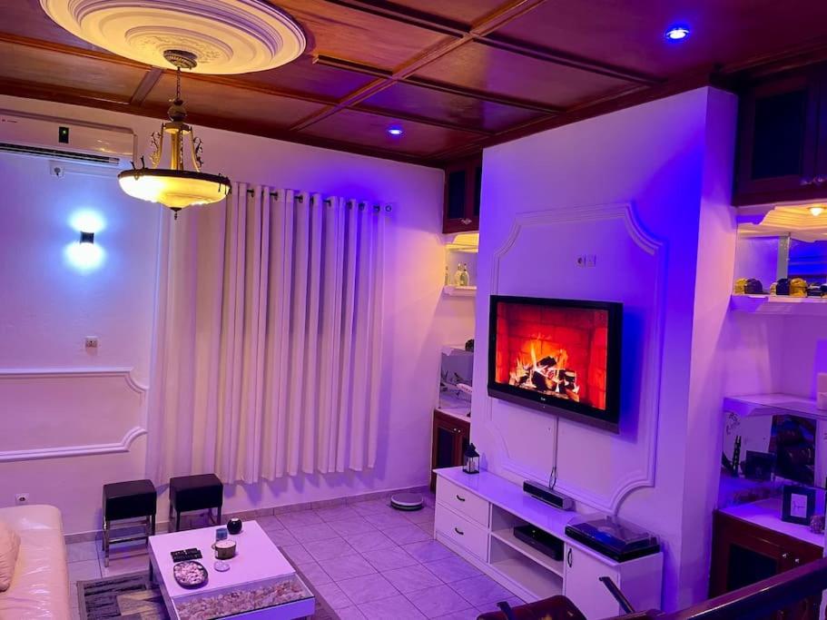 杜阿拉Mini villa cosy et discrete的一间带电视和紫色照明的客厅