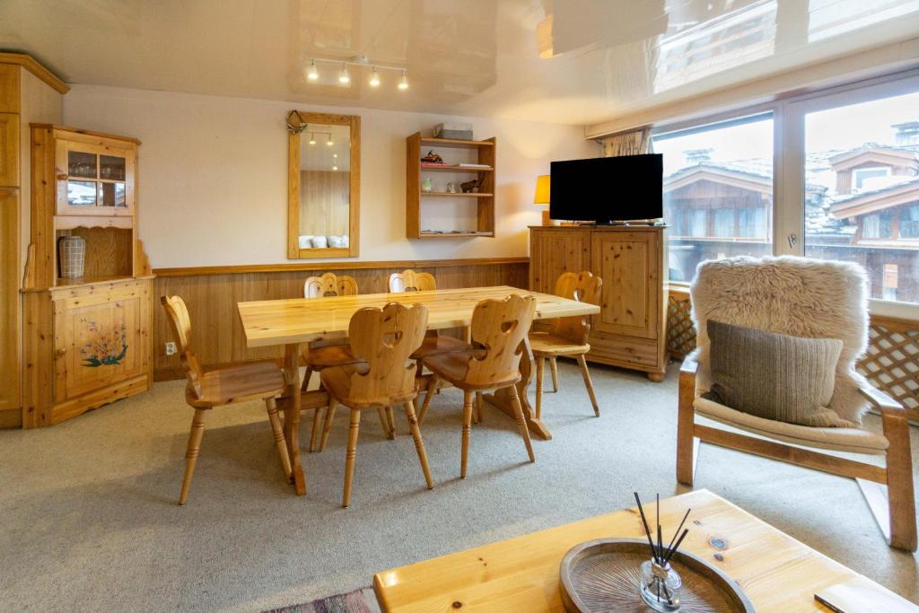 谷雪维尔Les marmottes的客厅配有木桌和椅子