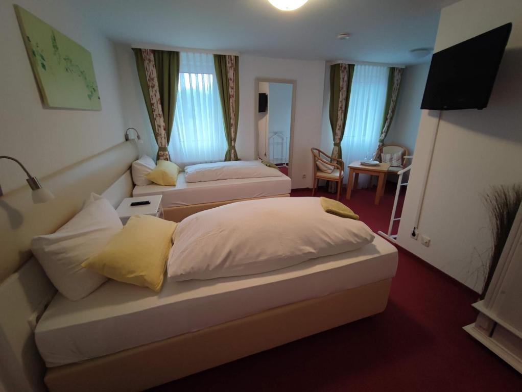 福尔巴赫Room in Guest room - Pension Forelle - Doppelzimmer的酒店客房,设有两张床和一张沙发