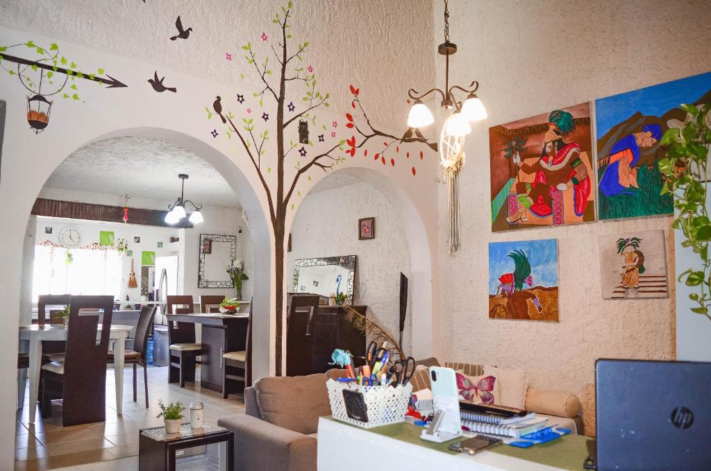 坎昆Naranjo Hostel的客厅配有桌子和树