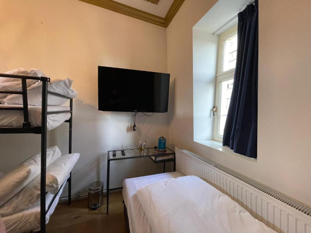 阿姆斯特丹Amsterdam Rembrandt Square city center Hotel的客房设有两张双层床和一台平面电视。