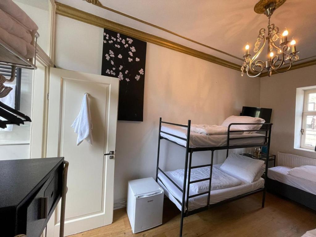 阿姆斯特丹Amsterdam Rembrandt Square city center Hotel的客房设有两张双层床和吊灯。