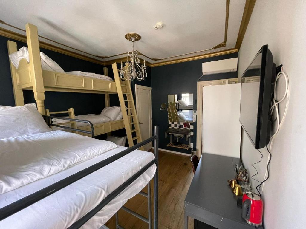 阿姆斯特丹Amsterdam Rembrandt Square city center Hotel的一间带两张双层床和一台电视的卧室