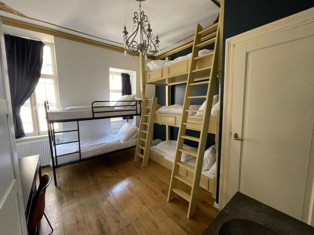 阿姆斯特丹Amsterdam Rembrandt Square city center Hotel的客房设有四张双层床和吊灯。