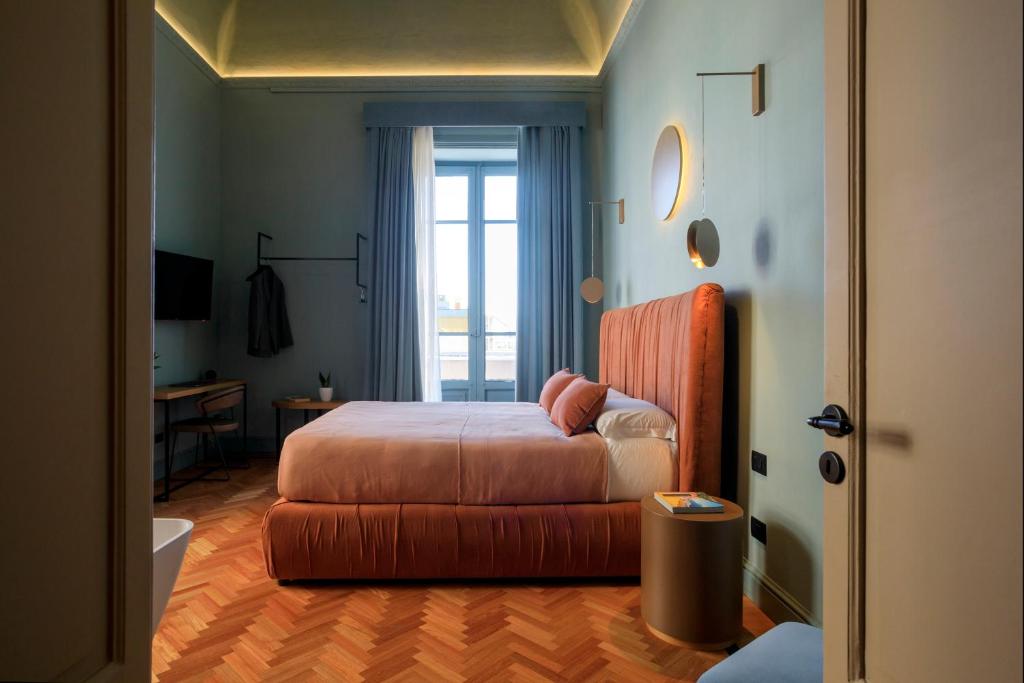 巴勒莫Maison Belmonte - Suites in Palermo的一间卧室配有一张床、一张书桌和一个窗户。