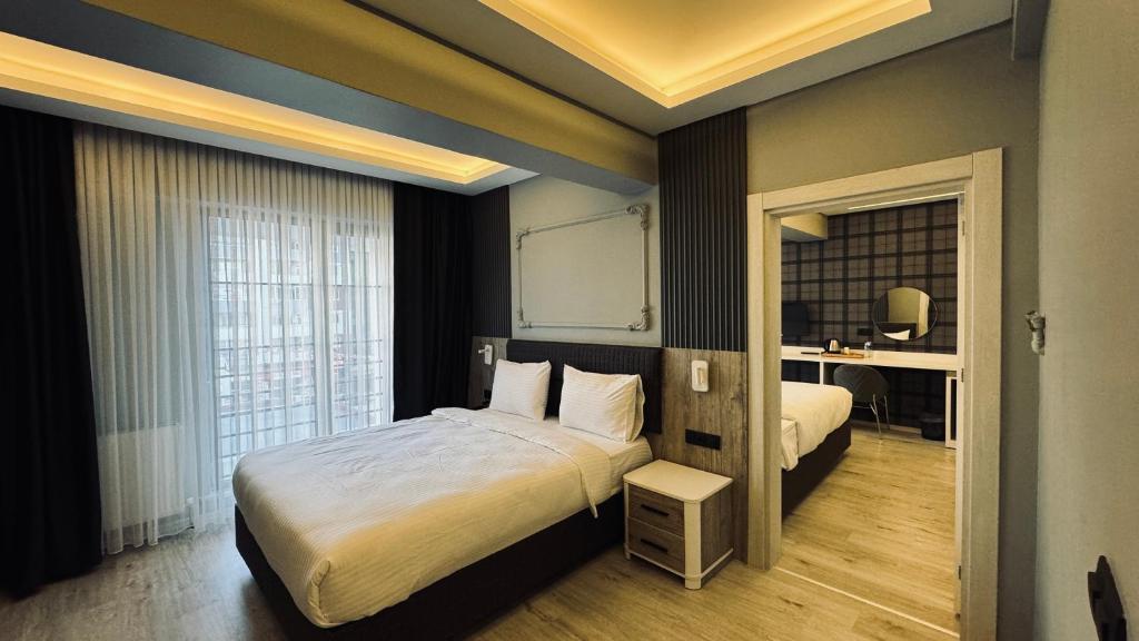 BostaniçiEl Baboos Hotel的酒店客房设有一张大床和一张书桌。