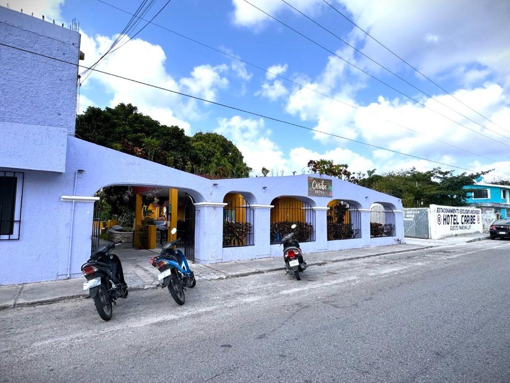 科苏梅尔Hotel Caribe的停在大楼前的两辆摩托车