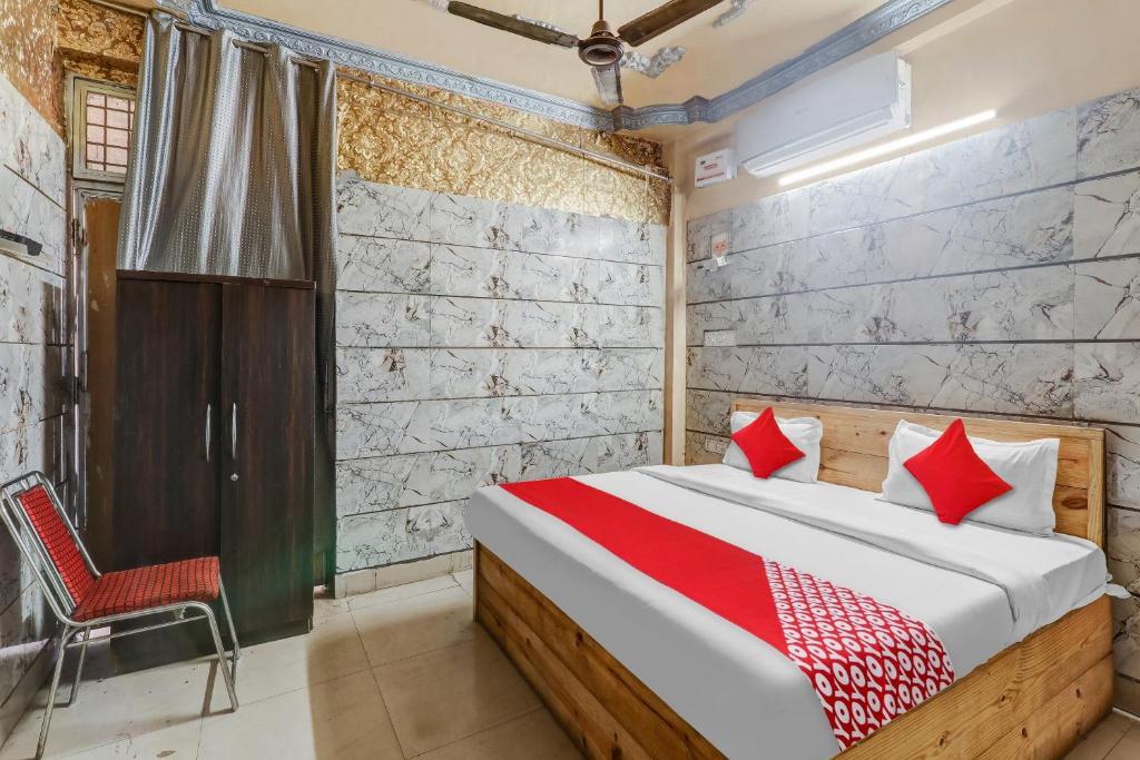 ChinhatFlagship Hotel Sai Palace Near Gomti Riverfront Park的一间卧室配有一张床和一把椅子