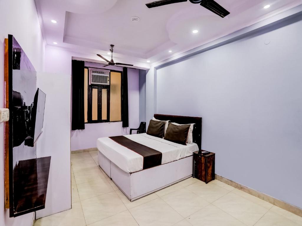 新德里Hotel Raaz Luxury Near Delhi Airport的卧室配有一张床,墙上挂有绘画作品