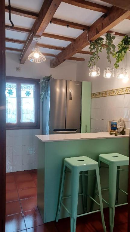 费雷列斯Casa en Ferreries的厨房在厨房柜台设有两张凳子