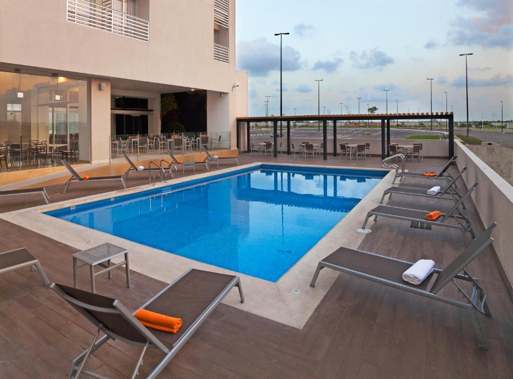 韦拉克鲁斯韦拉克鲁斯努埃沃酒店的一座带躺椅的游泳池和一座建筑
