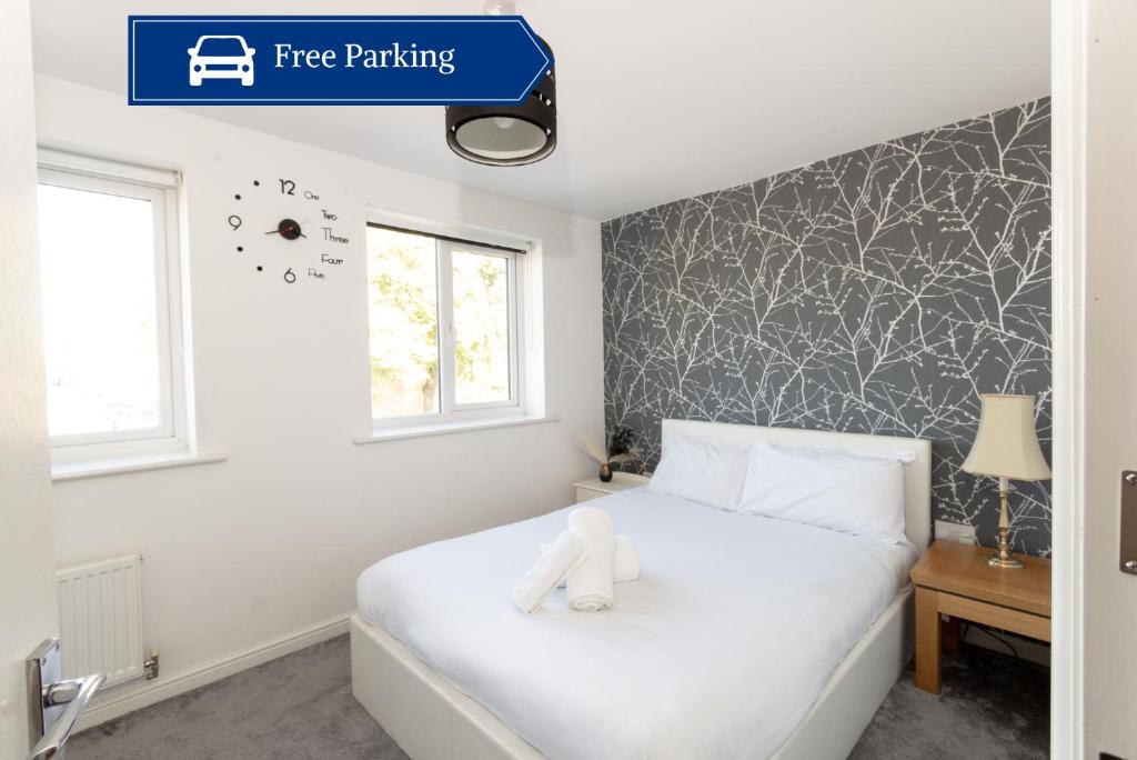 曼彻斯特Spacious 3BR House with Garden & Free Parking的卧室配有白色的床,上面有一只白色填充物动物